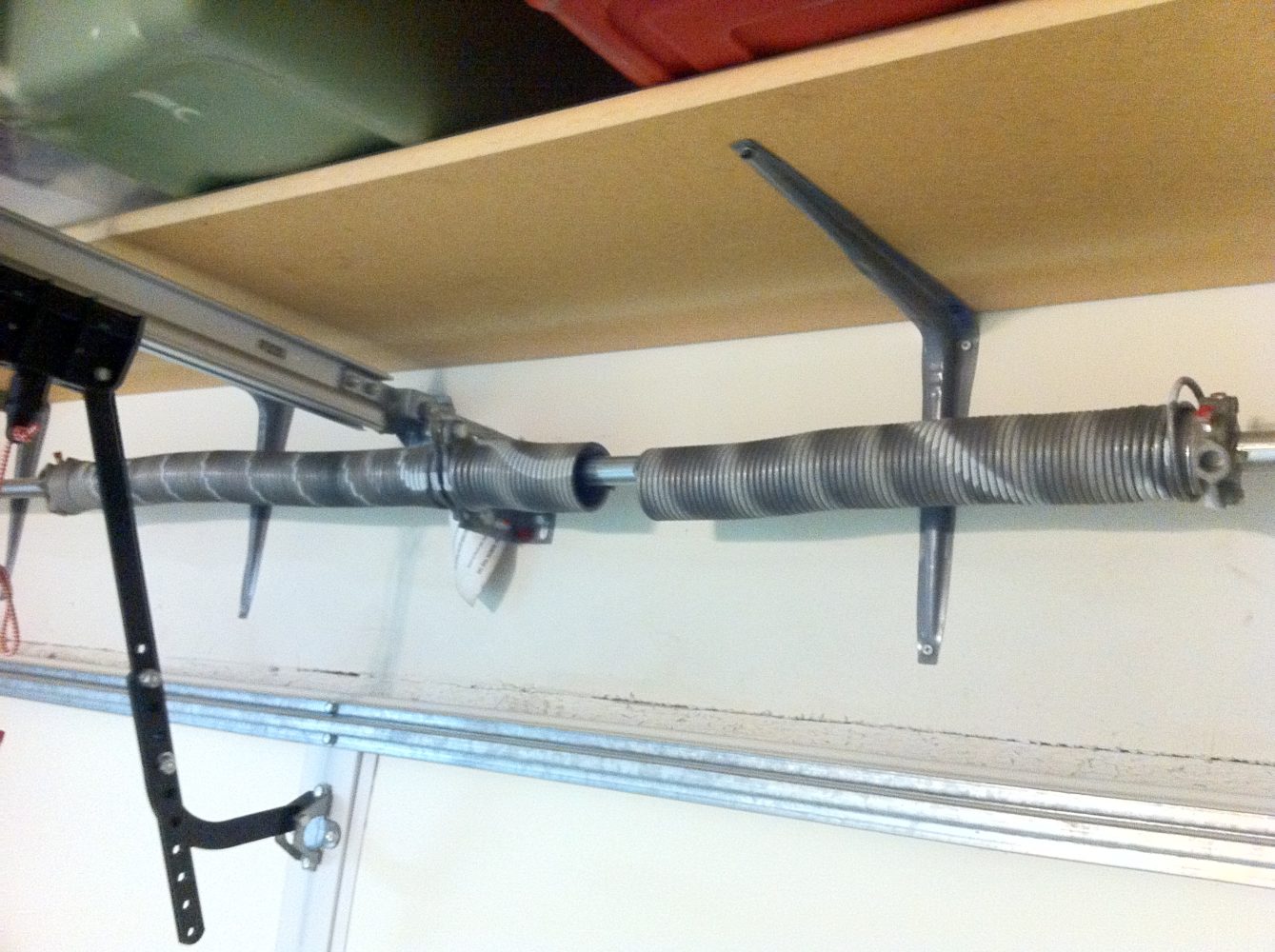 Technician replacing a garage door torsion spring.